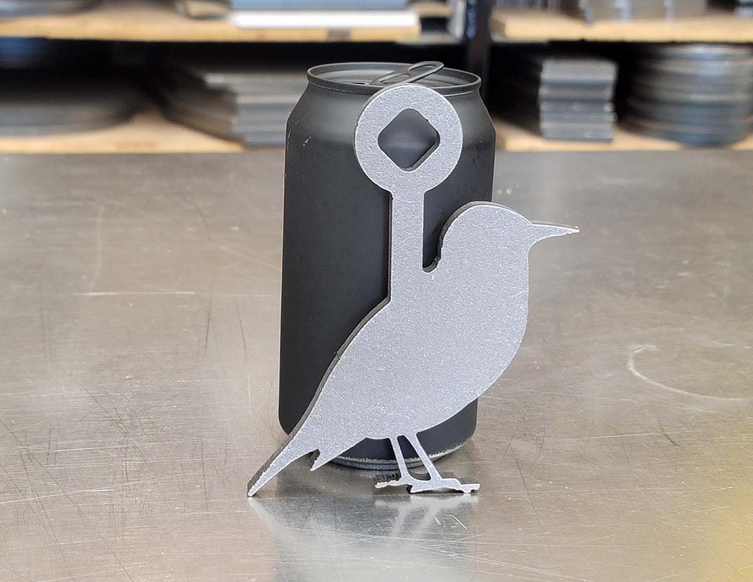 ar500 rimfire starling target next to a pop can for scale