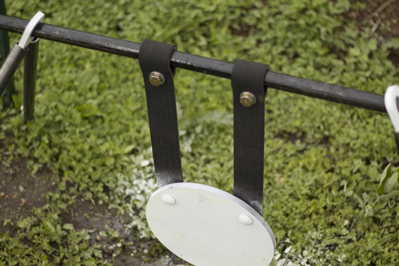 rubber steel target gong hanging straps wrapped around black pipe